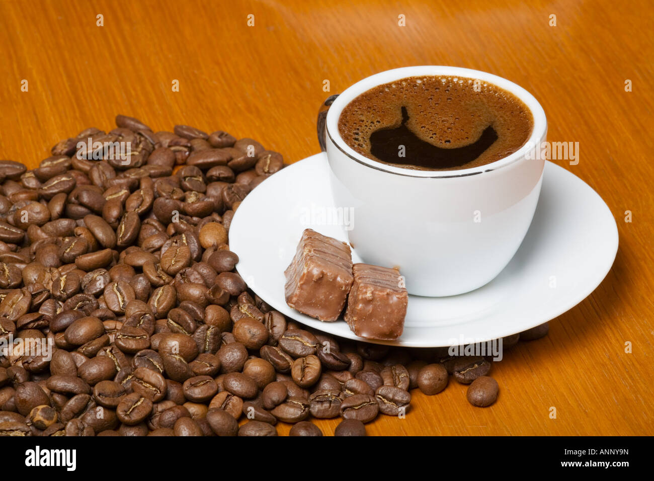 Tasse de café blanc avec des haricots et du chocolat Banque D'Images