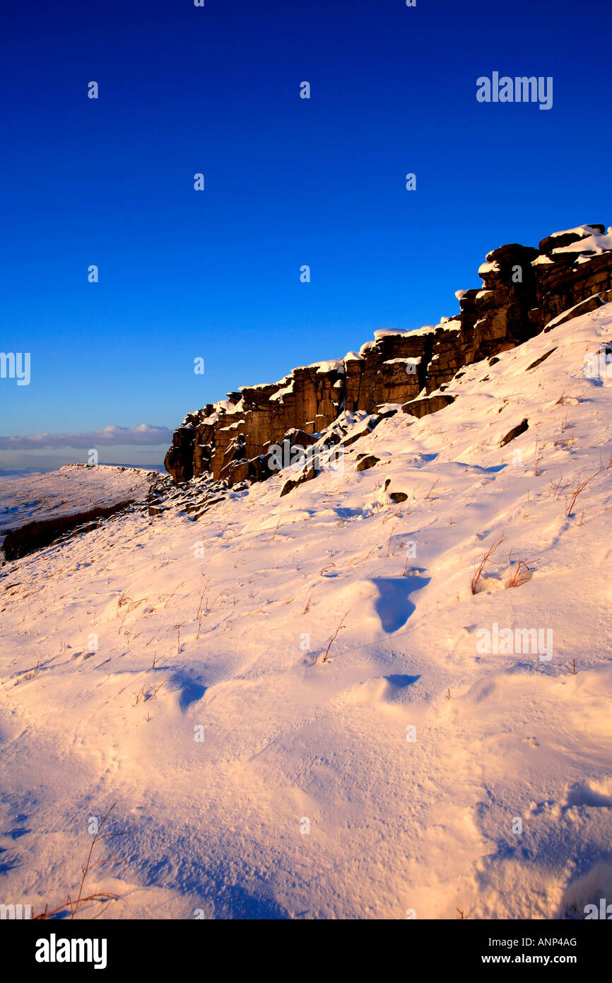 La fin de l'hiver Coucher du soleil sur la neige Stanage Edge Parc national de Peak District Derbyshire, Angleterre Royaume-uni Grande-Bretagne Banque D'Images