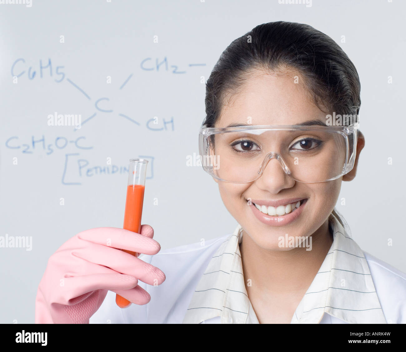 Portrait of a female Lab technician holding un tube à essai et souriant Banque D'Images
