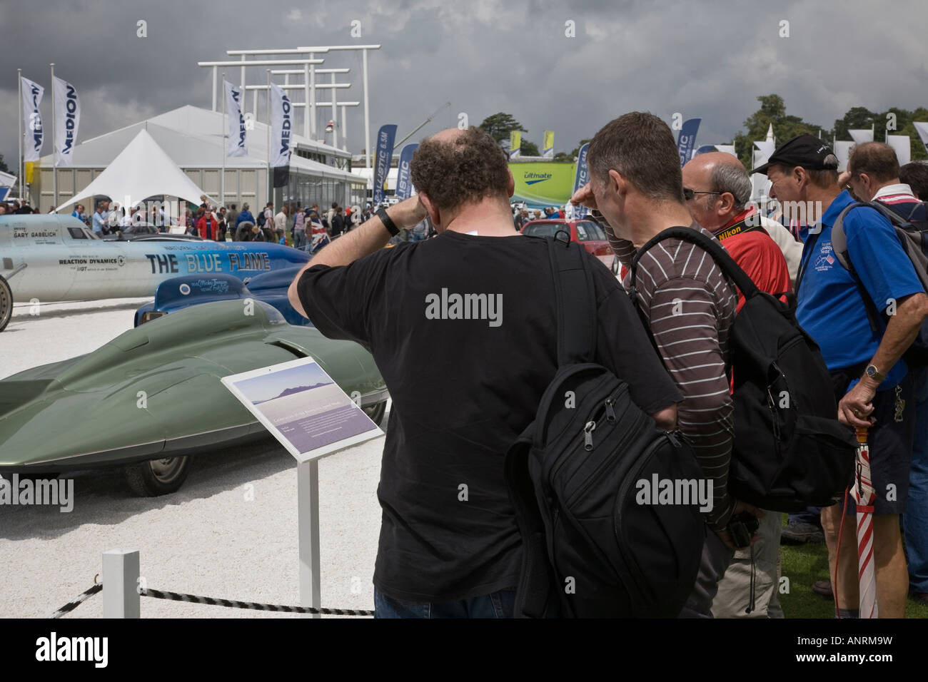 Les badauds afficher divers voitures record de vitesse sur l'affichage à la Goodwood Festival of Speed, Goodwood, West Sussex, Angleterre. Banque D'Images