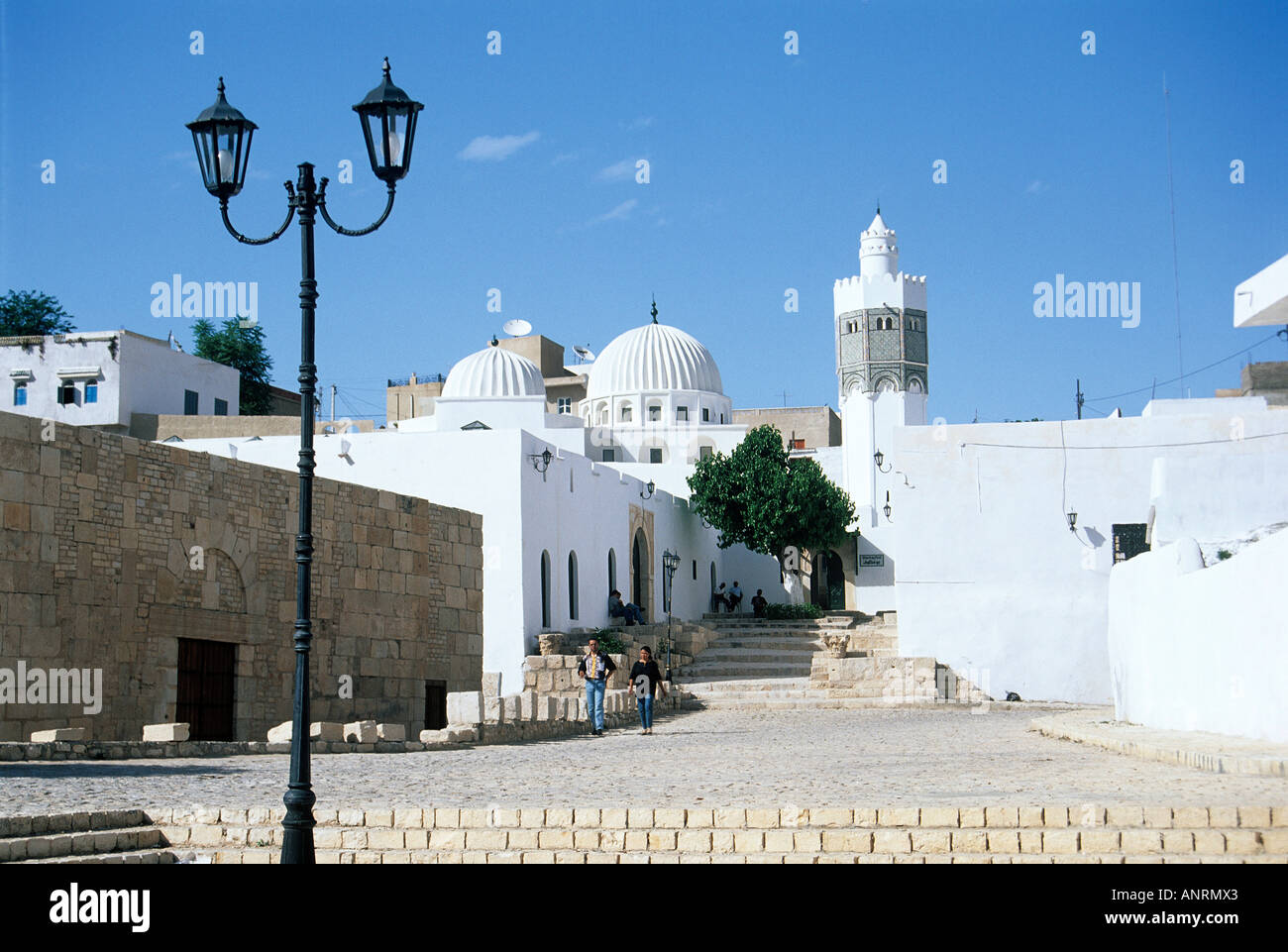 Au-dessus de l'ancienne mosquée escaliers usés l'approche des murs blanchis à la chaux étincelant de la mosquée de Sidi Bou Makhlouf avec sa paire de dômes sculptés et minaret octogonal Banque D'Images