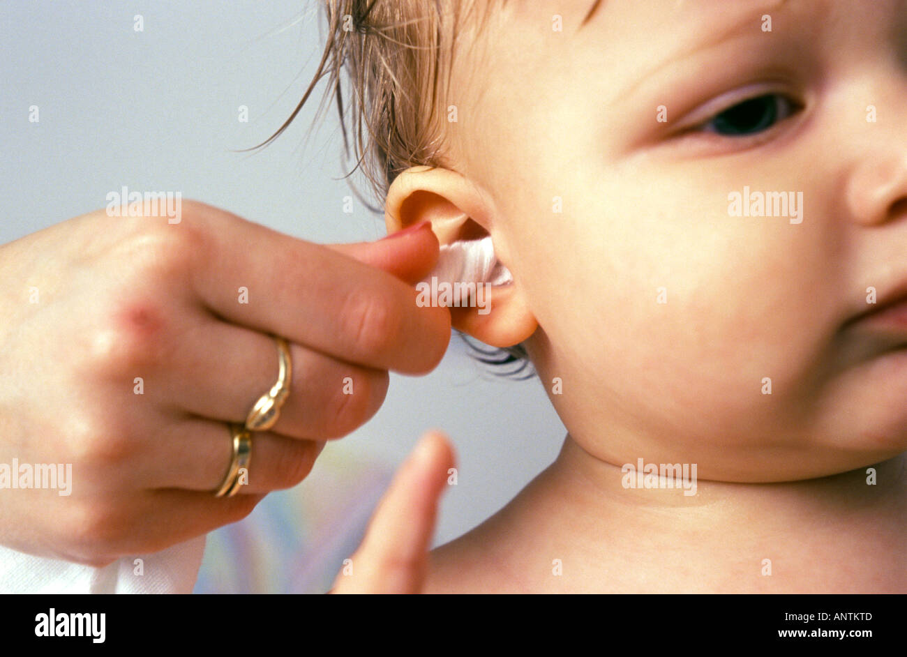 Le nettoyage de l'oreille du bébé avec une serviette après bain Banque D'Images