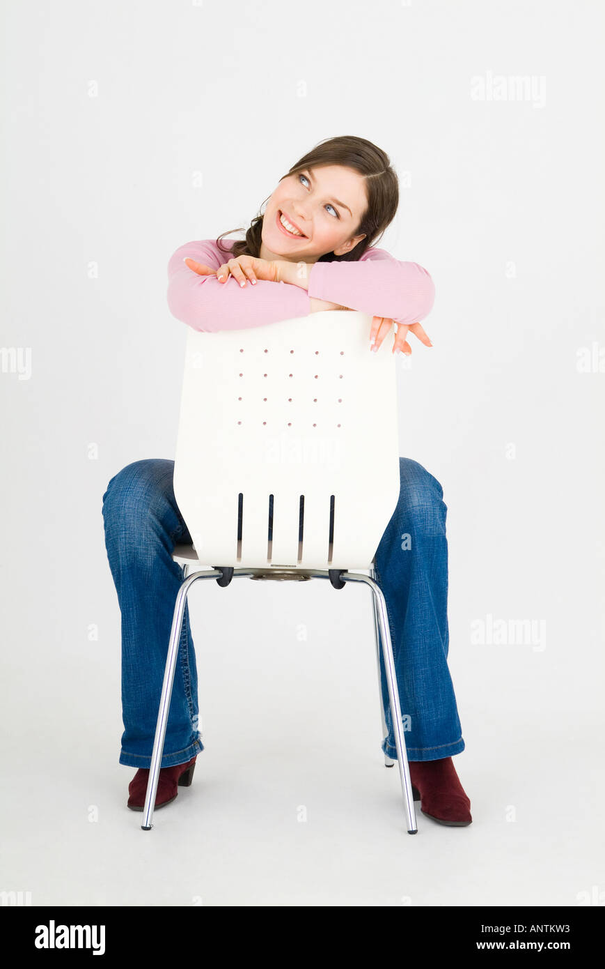 Jeune femme assise à l'envers sur une chaise Photo Stock - Alamy