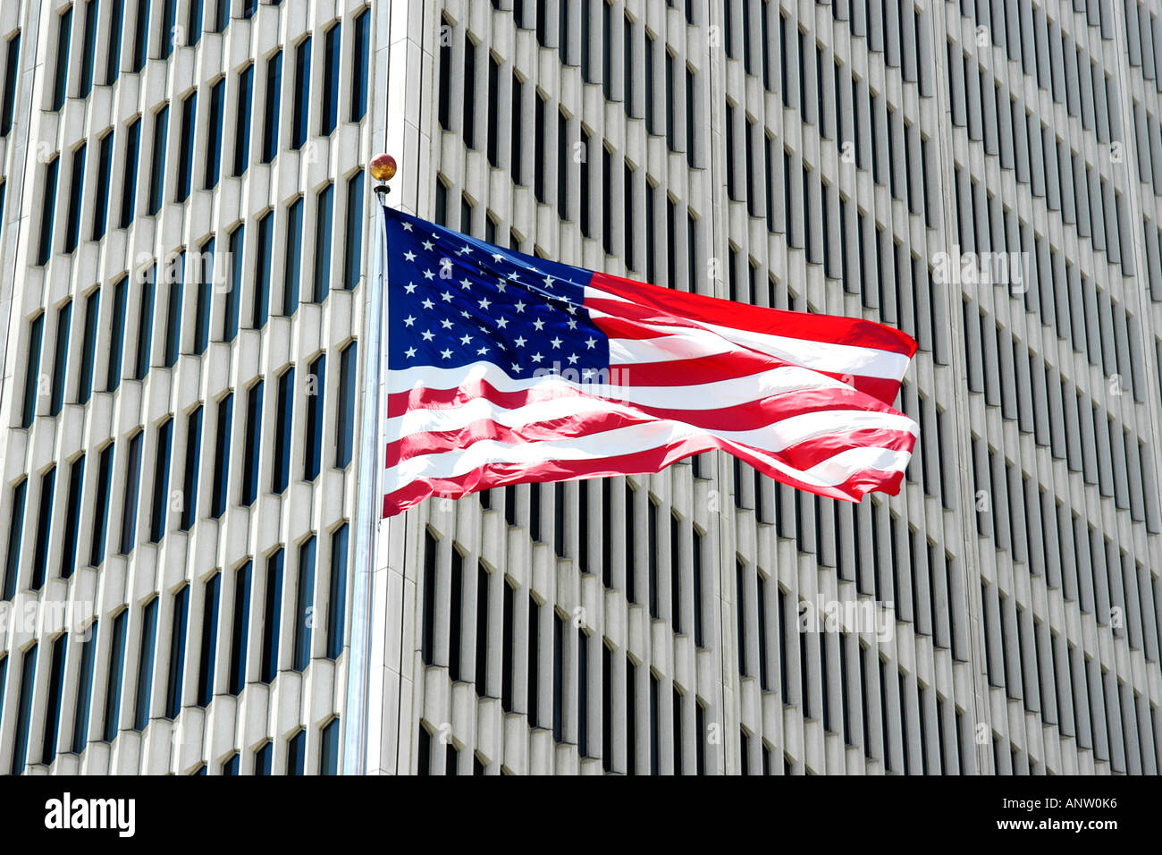 Le drapeau américain de haut vol en face d'un gratte-ciel dans le centre-ville de Detroit Michigan MI Banque D'Images