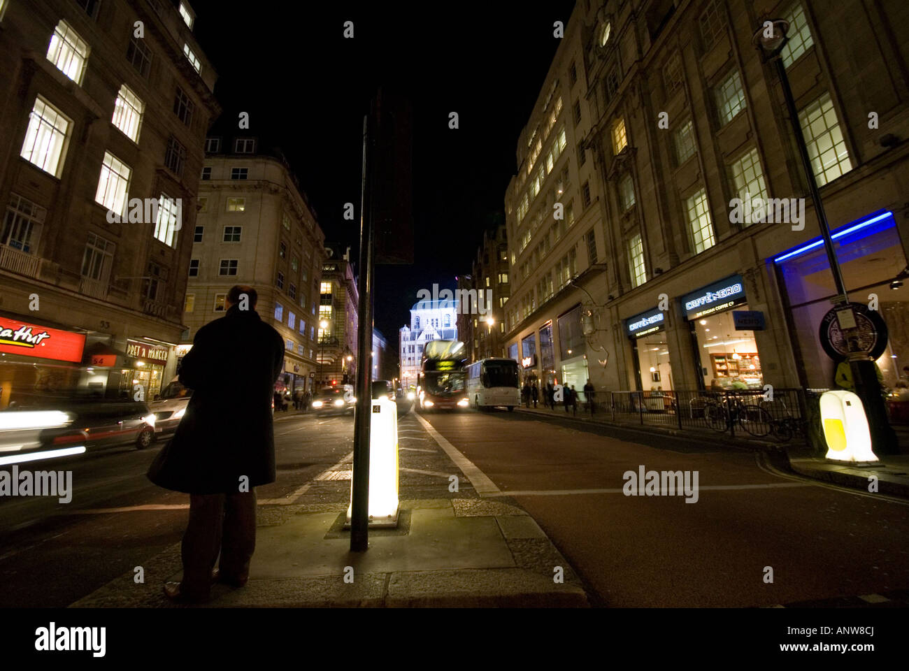 Piccadilly Circus homme attendre pour traverser la rue à Londres la nuit Banque D'Images