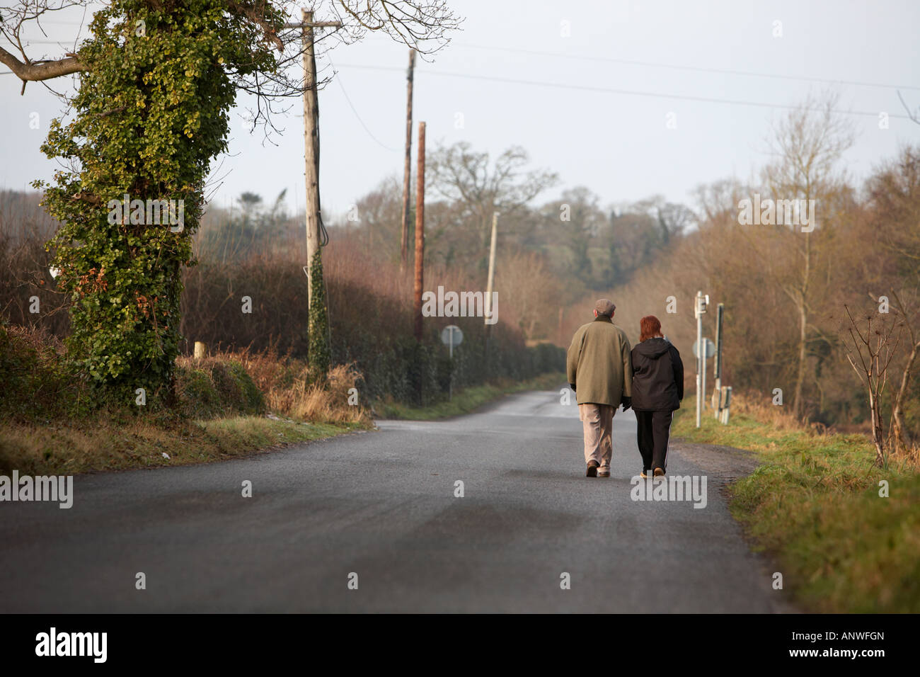 Middel de couple en train de marcher ensemble le long chemin de campagne en hiver du matin Banque D'Images