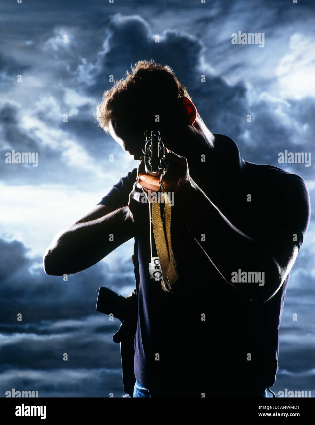 L'homme au fusil silhouetted against sky Banque D'Images