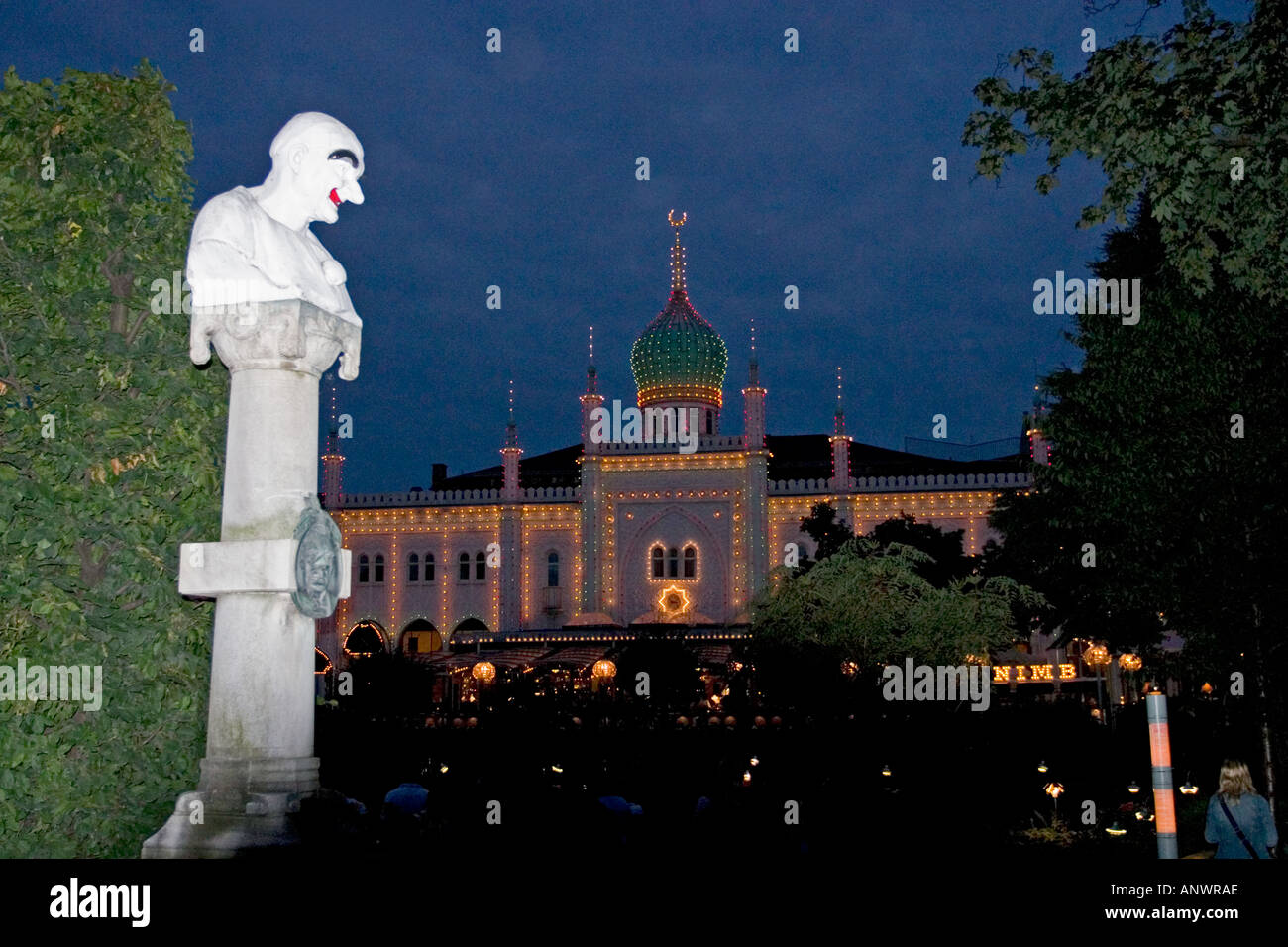 Bazar domaine de Tivoli Gardens au crépuscule avec sculpture de clown blanc en premier plan Copenhagen Danemark Banque D'Images