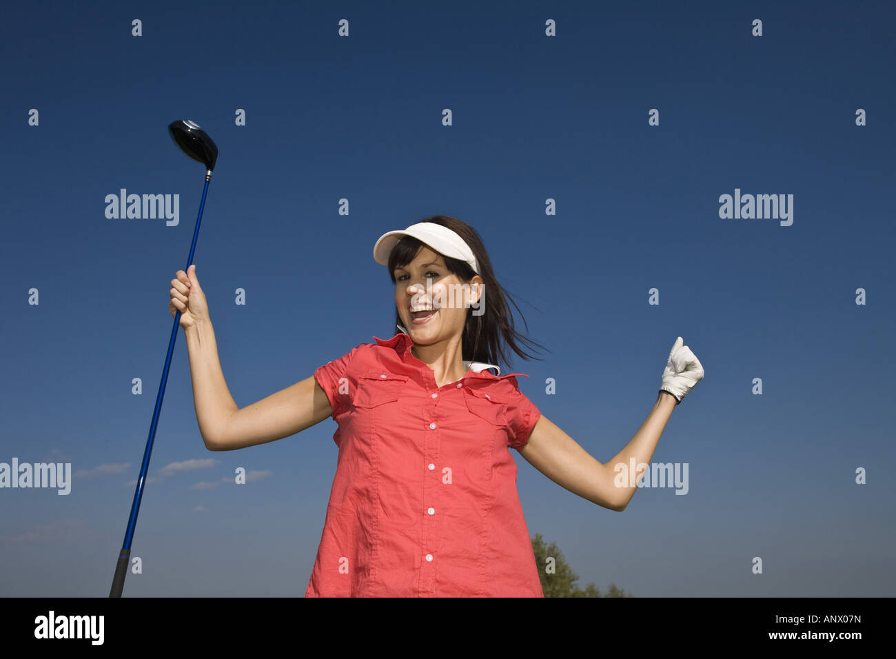 Femme avec golf club cheering Banque D'Images