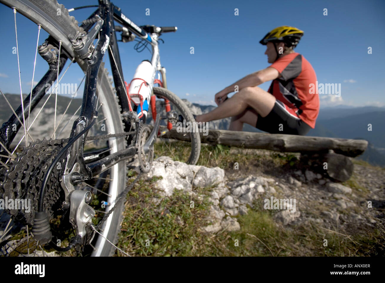 Mountainbiker ayant une pause sur un banc en bois, de l'Autriche, Styrie, Alpes Banque D'Images