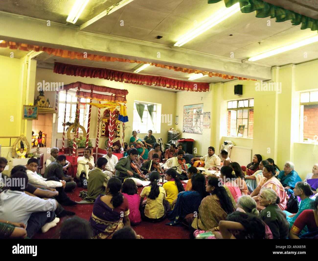 B0078P 0047 Temple Murugan New Malden Surrey Angleterre les gens à l'écoute de musiciens pendant la cérémonie Banque D'Images