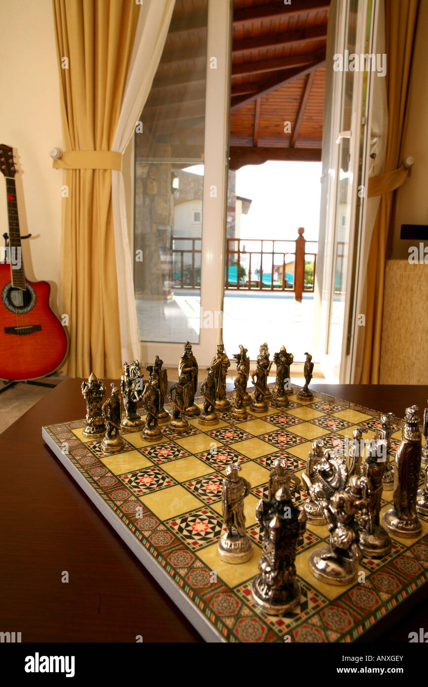 Le jeu d'échecs exotiques avec guitare et voir à travers la vitre à sun patio en arrière-plan Banque D'Images