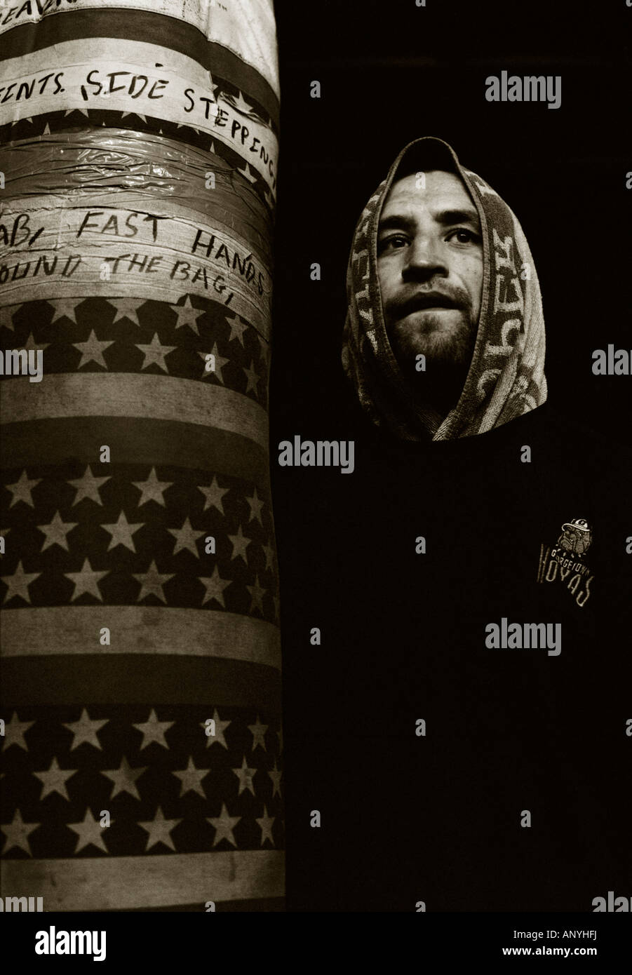 Portrait noir et blanc d'un boxeur debout à côté d'un sac. Banque D'Images