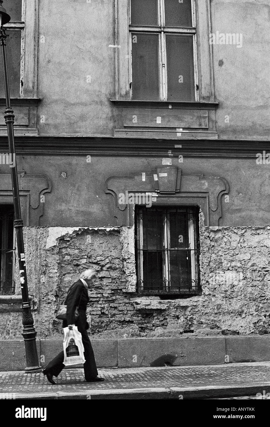 Une vieille femme marche dans les rues de Prague Banque D'Images