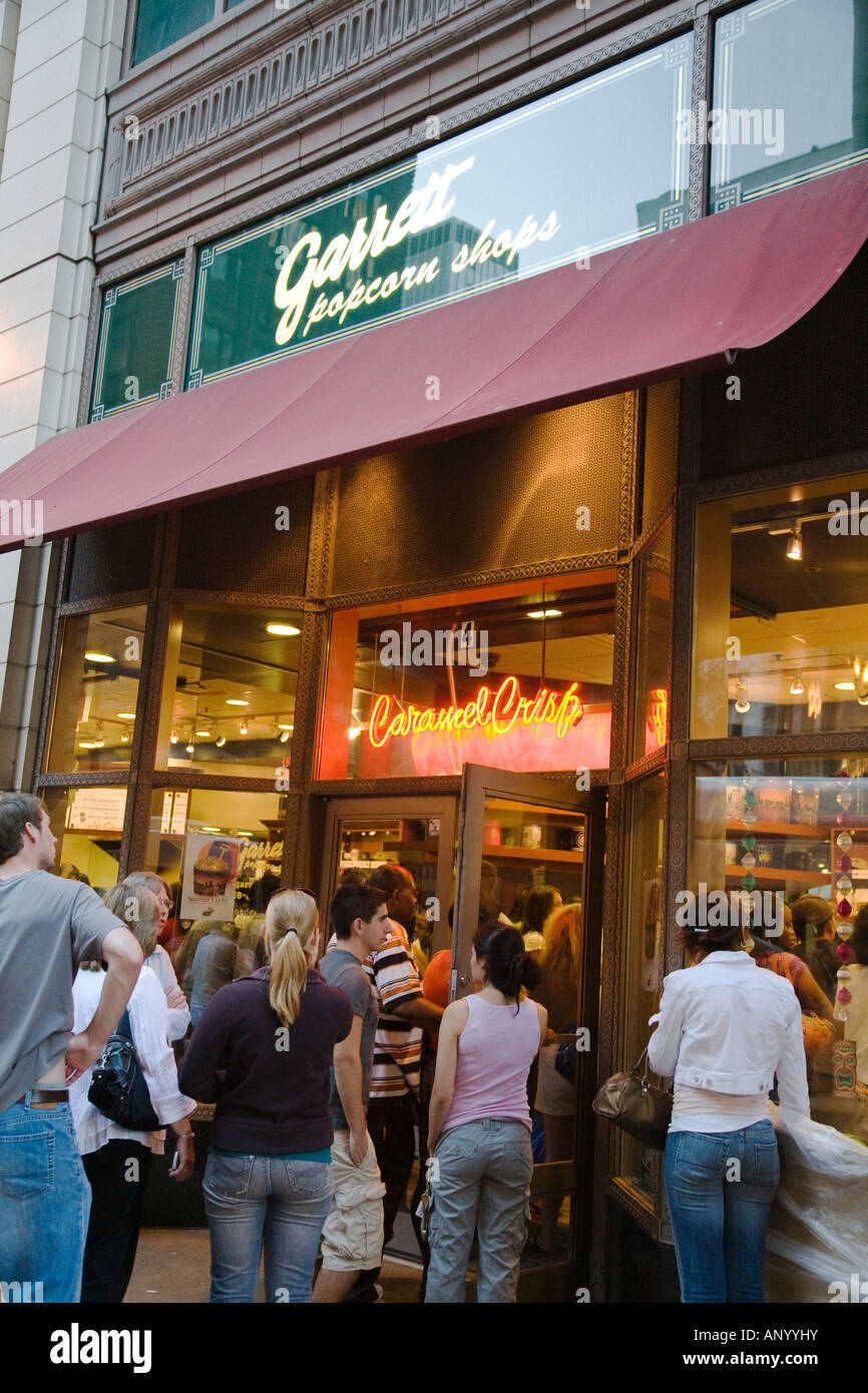 L'ILLINOIS Chicago personnes attendent en ligne pour entrer Garretts popcorn store boutique de vente au détail au centre-ville bondé soir Banque D'Images
