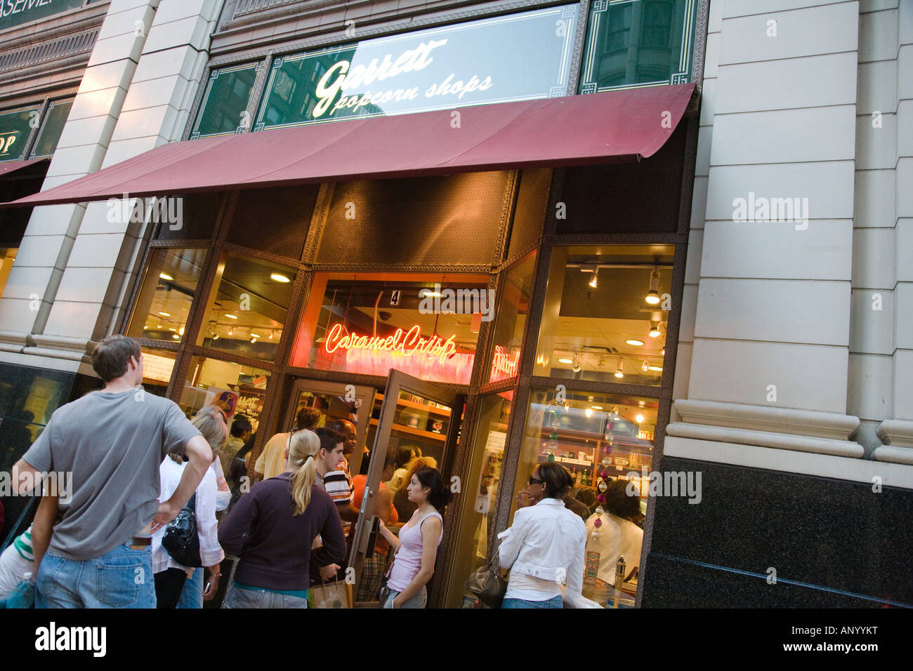 L'ILLINOIS Chicago personnes attendent en ligne pour entrer Garretts popcorn store boutique de vente au détail au centre-ville bondé soir Banque D'Images