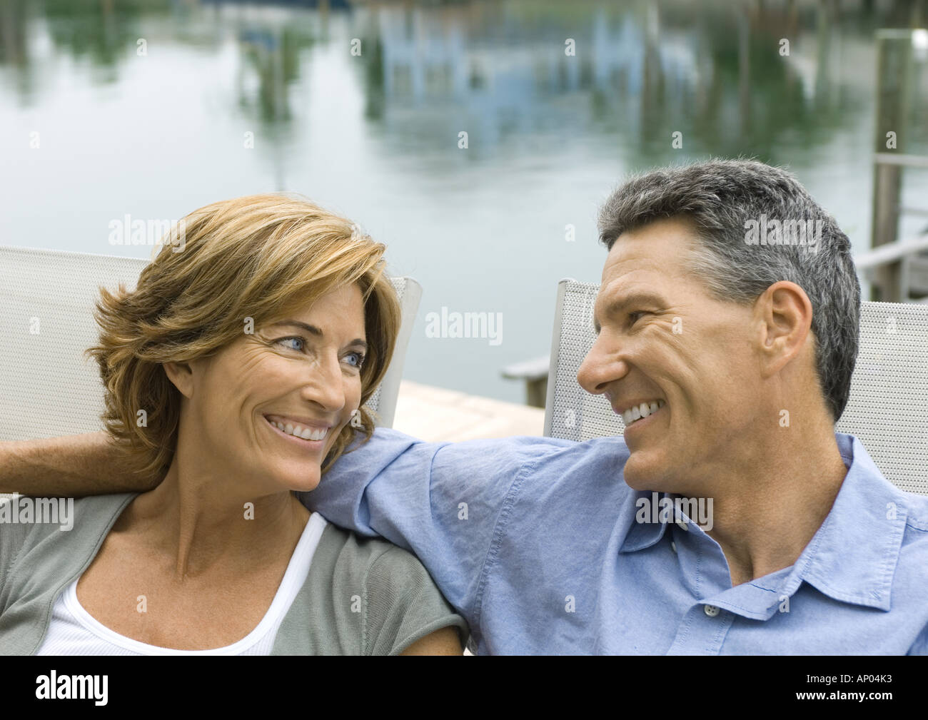Couple près de l'eau, smiling at each other Banque D'Images