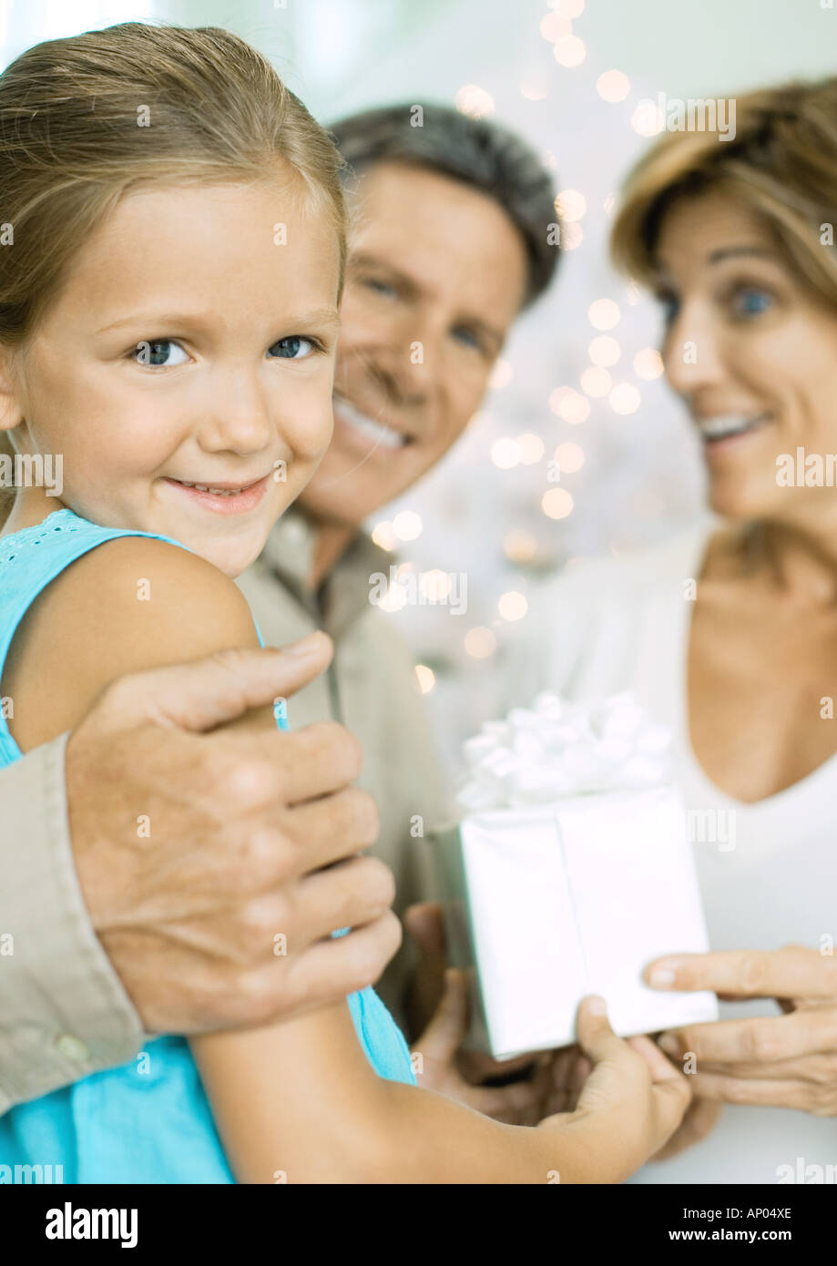 Petite fille donnant les grands-parents cadeau de Noël Banque D'Images