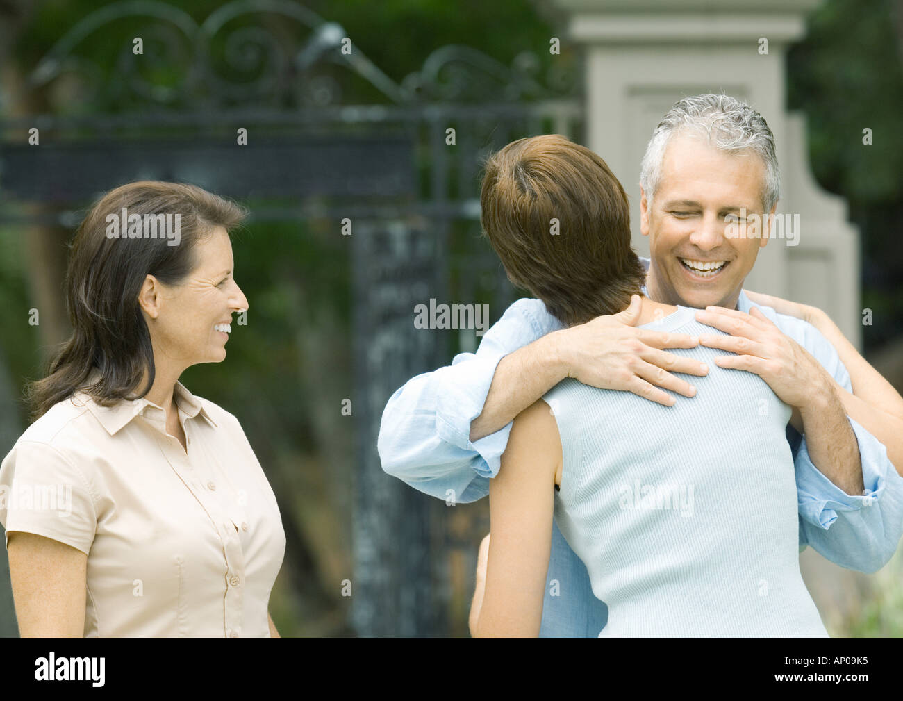 Woman hugging man en tant que deuxième femme montres, smiling Banque D'Images