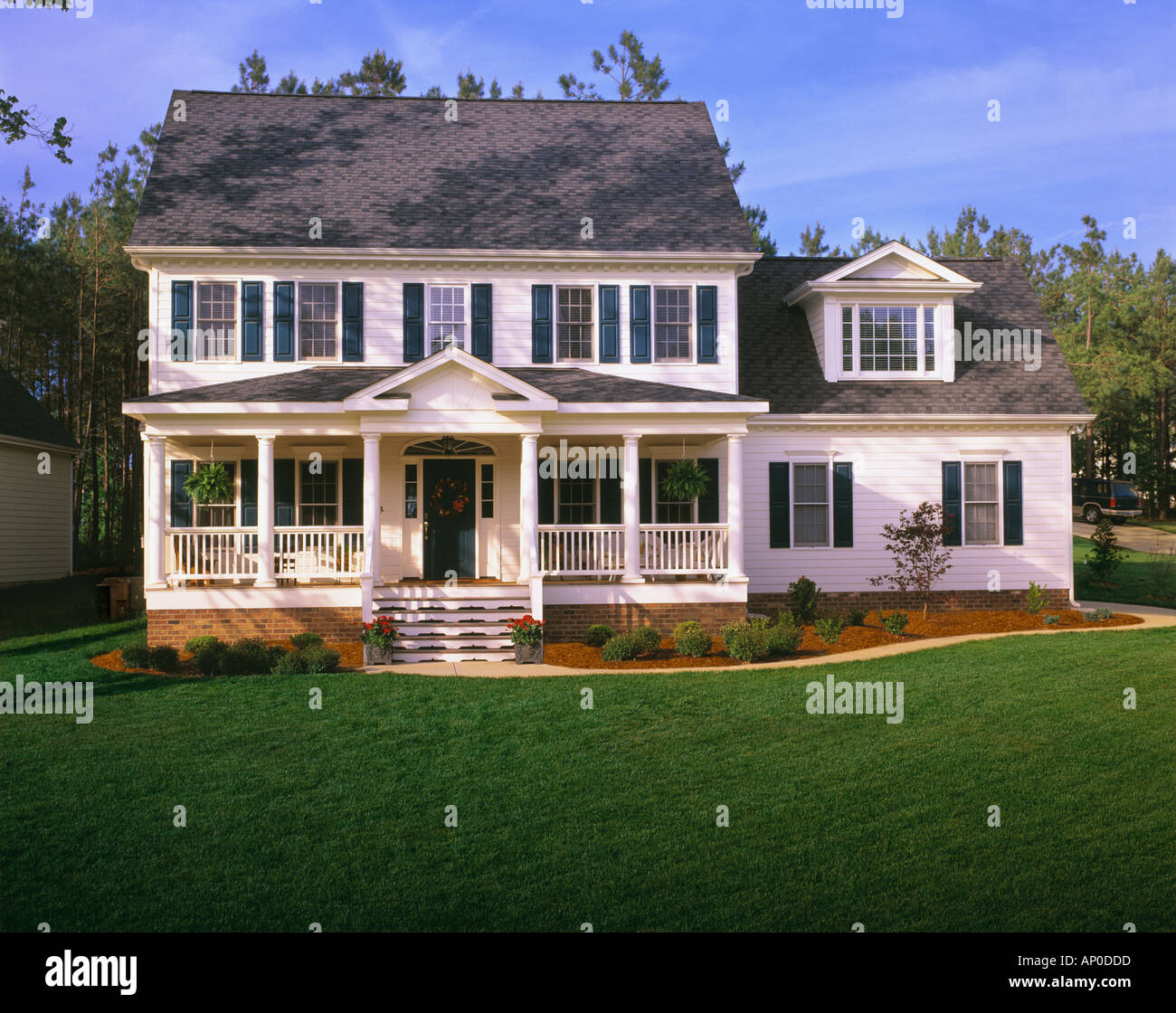 Grande maison de deux étages blanc aux volets bleus un porche et grande pelouse Banque D'Images