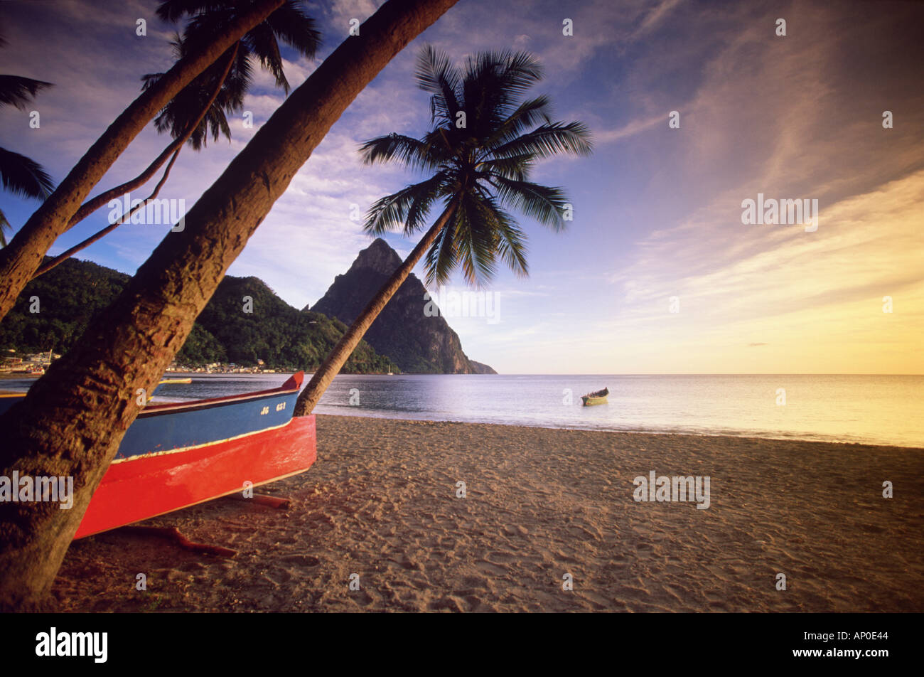 La tour des Pitons, au-dessus de la plage de Soufriere, sur l'île des Caraïbes de Sainte-Lucie, tandis que des bateaux de pêche sont sur la plage Banque D'Images