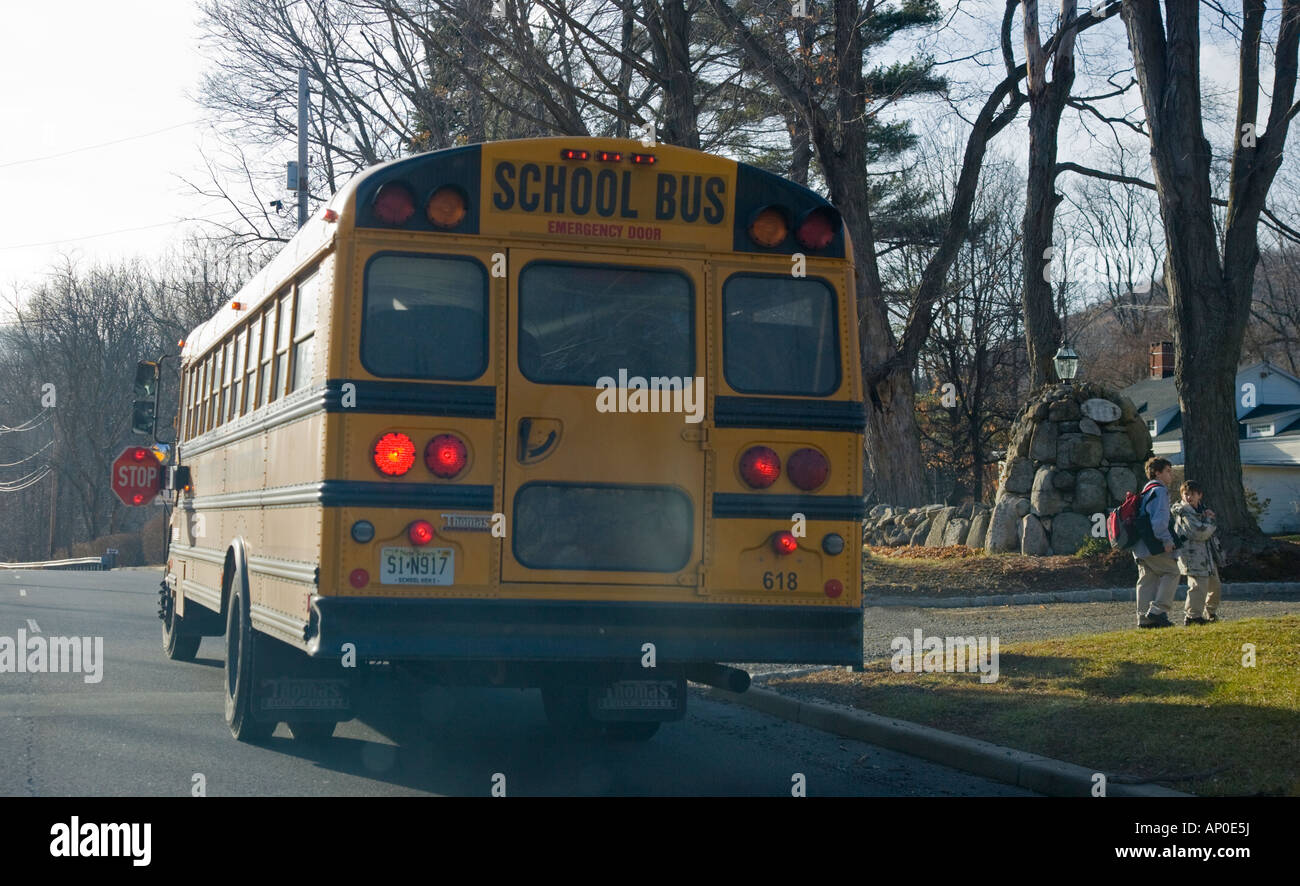 Deux enfants de descendre d'un autobus scolaire Banque D'Images