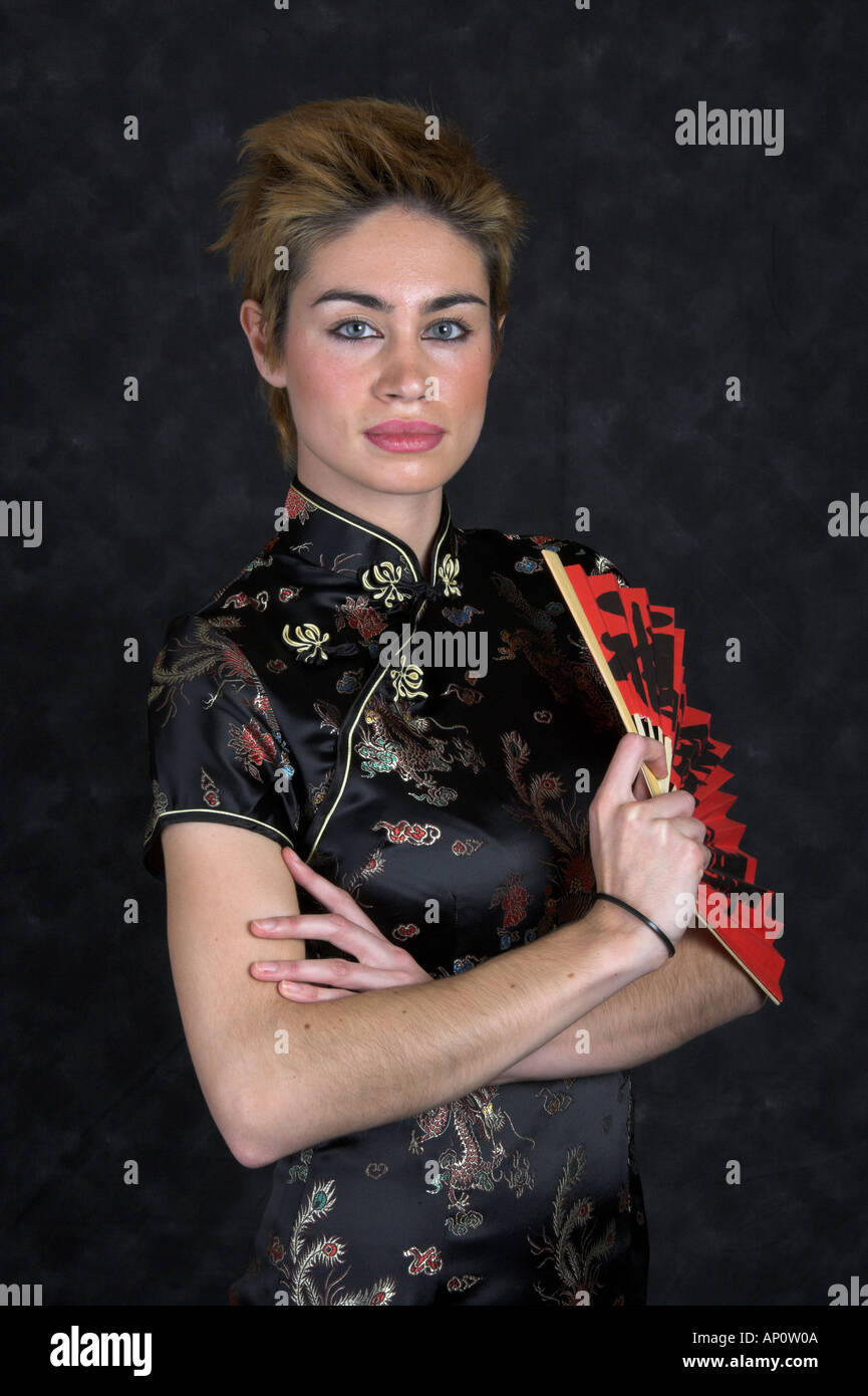 Portrait d'une jeune femme dans une robe chinoise avec un ventilateur rouge Banque D'Images