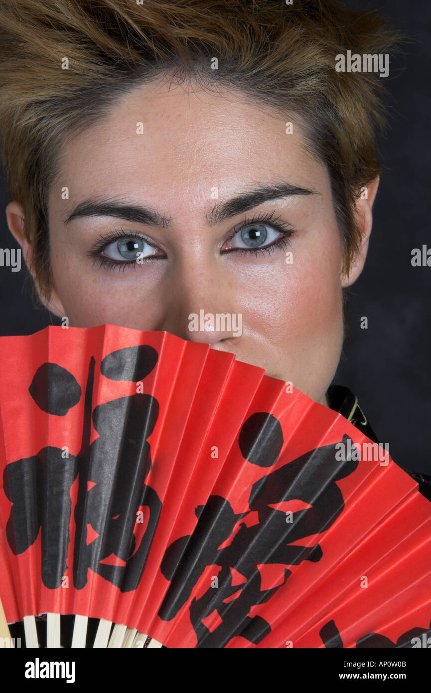 Portrait d'une jeune femme avec un ventilateur rouge Banque D'Images
