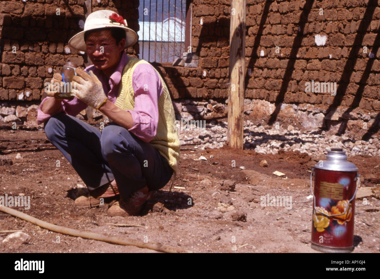 Travailleur de la construction en faisant une pause thé potable à partir de pots de confiture près de Lijiang dans la province du Yunnan en Chine. Banque D'Images