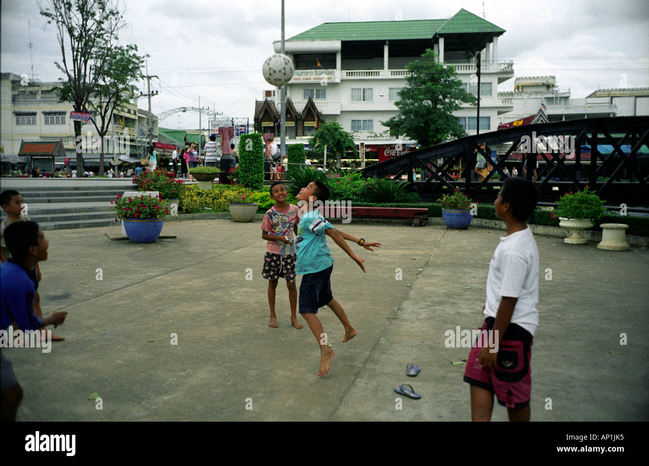 Thaïlande LES GARÇONS JOUENT AU FOOTBALL PRÈS DU PONT SUR LA RIVIÈRE KWAI à Kanchanaburi Banque D'Images