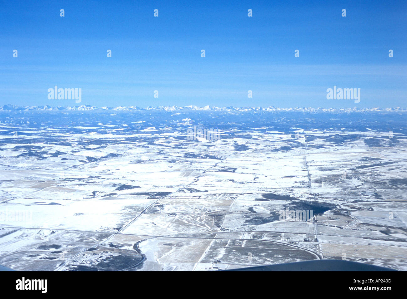 Prairies couvertes de neige près de Calgary, en Alberta, avec des Montagnes Rocheuses les Rocheuses au loin tourné à partir d'un avion de ligne commercial Banque D'Images