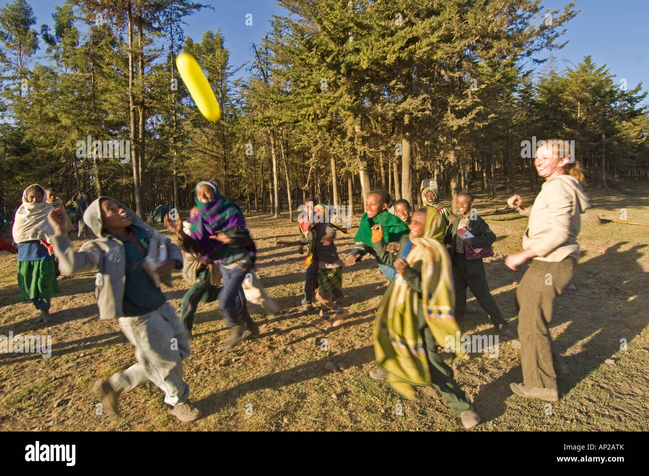 Un touriste à jouer avec les enfants essayant d'attraper un ballon. Banque D'Images