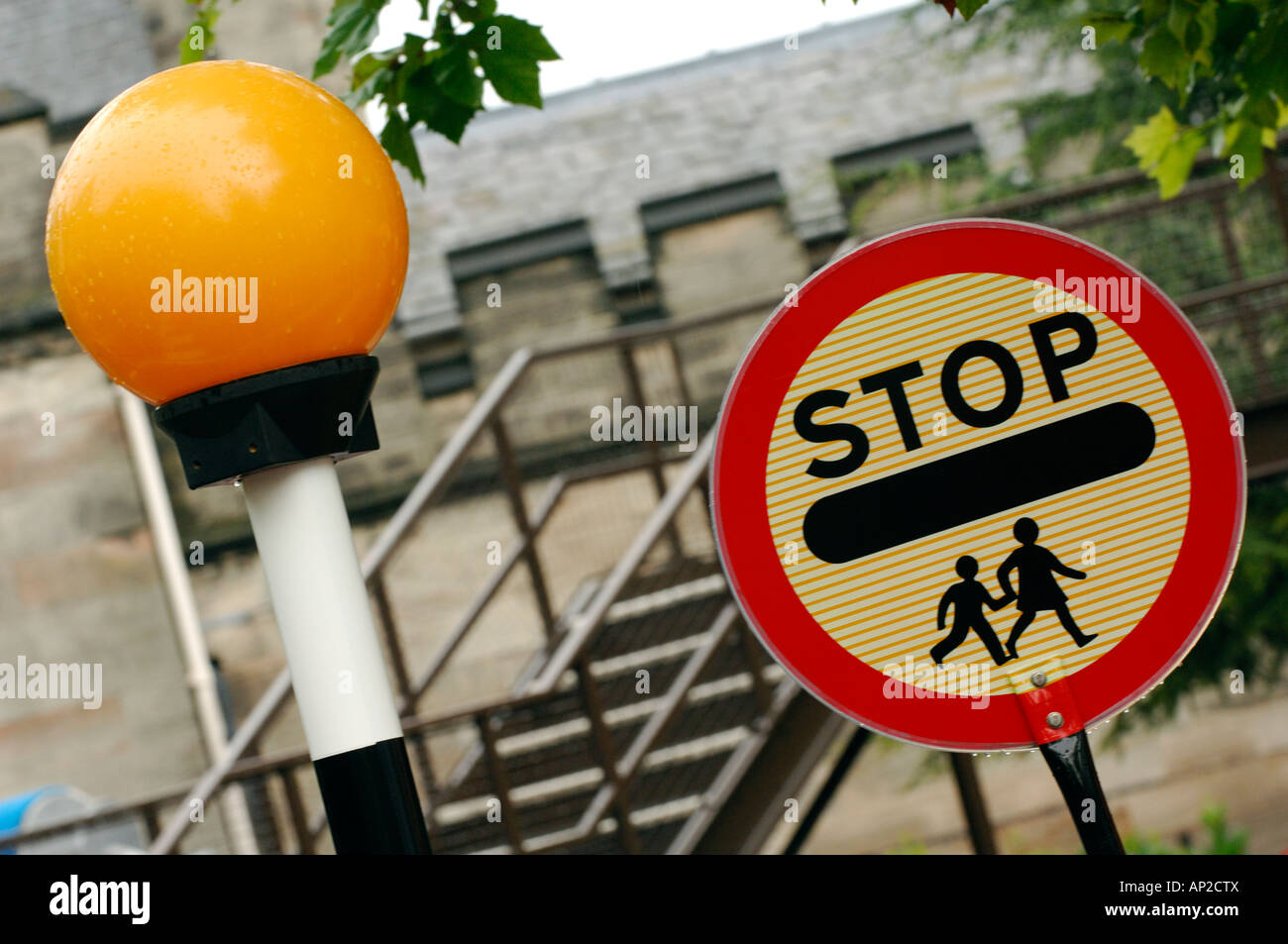 Un panneau d'arrêt et de la balise à une école pour enfants ou croisement avec un zèbre et clignotant orange Banque D'Images