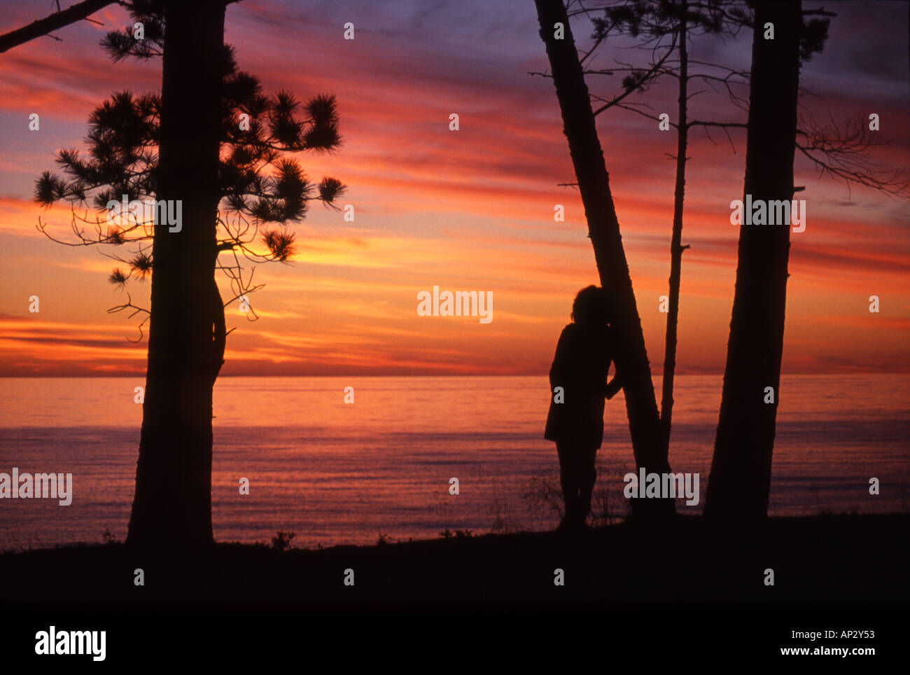 Fille regardant le coucher du soleil du lac de falaise Banque D'Images