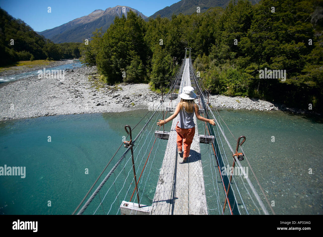 Fille sur le pont suspendu, la bonne voie pour piscines bleu, à l'est de Haast Pass, Alpes du Sud, l'île du Sud, Nouvelle-Zélande Banque D'Images