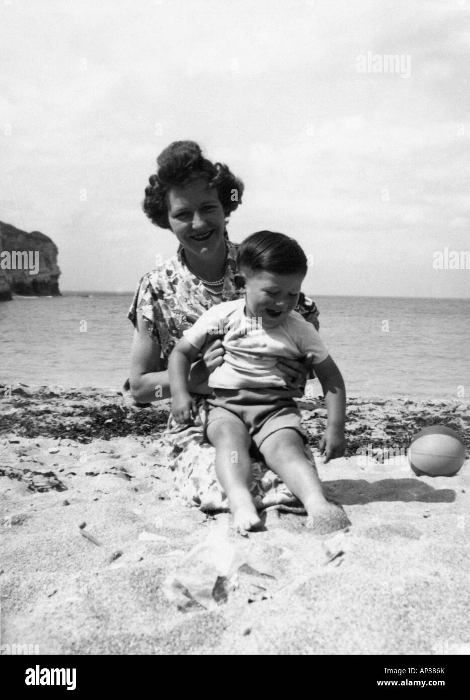 Famille ANCIENNES EN NOIR ET BLANC PORTRAIT INSTANTANÉ DE LA MÈRE ET LE Fils De Jouer Sur Une Plage Vers 1950 15660810