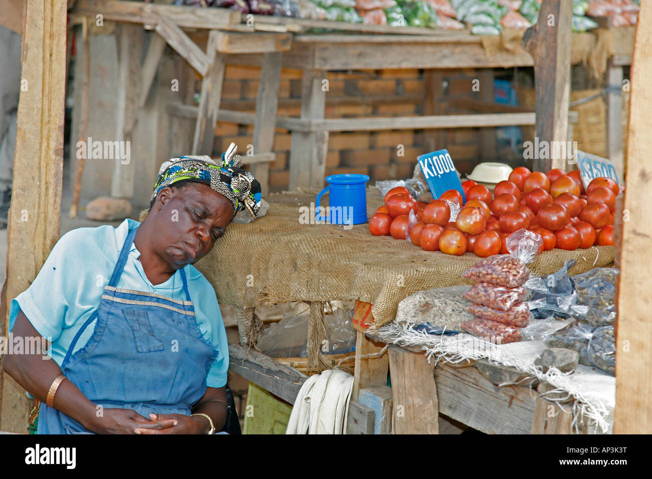 Femme noire africaine s'endormir, tandis que la vente d'aliments au marché local dans la ville de Kitwe, Copperbelt, en Zambie, l'Afrique. 'Sleeping humoristique de service' de droit. Banque D'Images