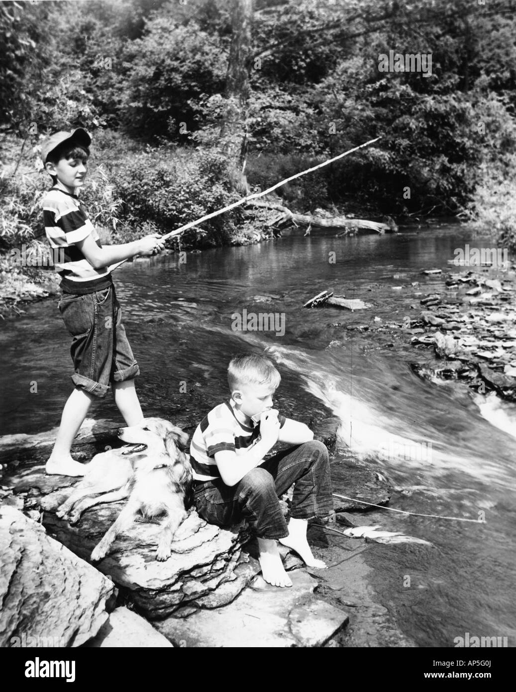 Les garçons sans soucis avec leur chien de pêche Banque D'Images