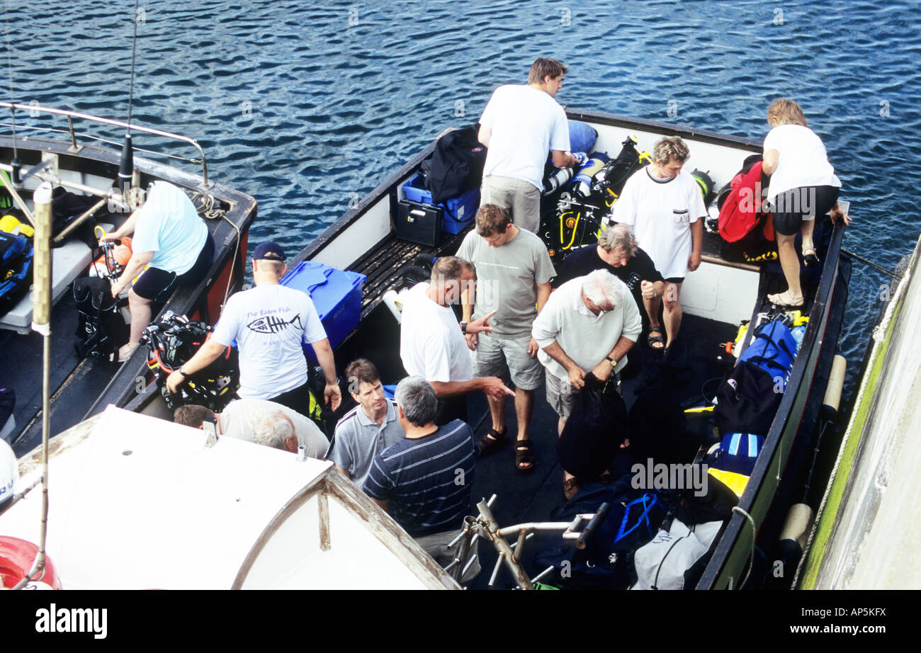 Les amateurs de plongée sous-marine, le rangement et l'assemblage de leur équipement de plongée, avant le départ pour l'Iles Farne. Port de Seahouses. Le Northumberland Banque D'Images
