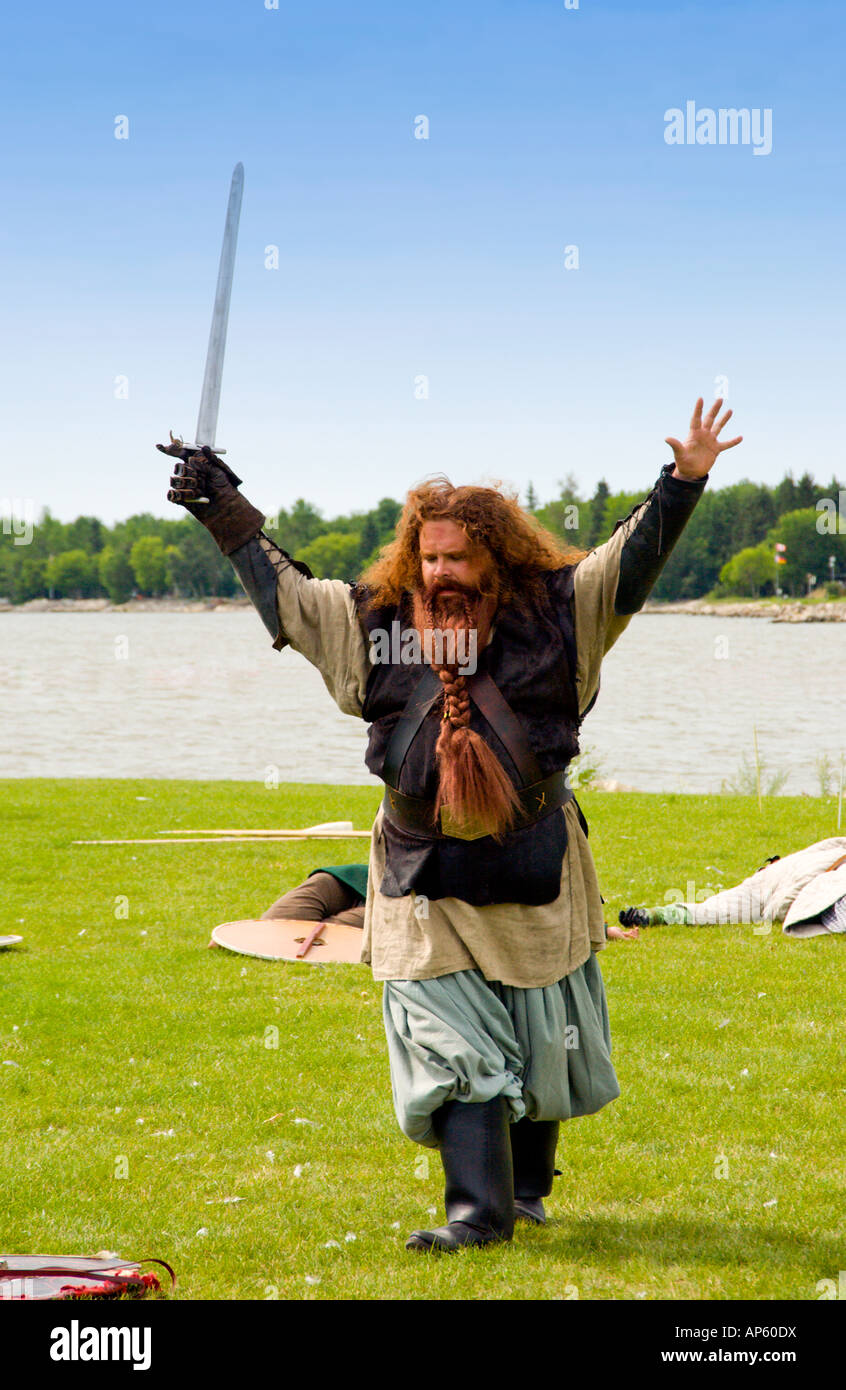 Un guerrier solitaire dans un cri de guerre à un reinactment d'un Viking islandais bataille en vêtements traditionnels à Gimli, au Manitoba, Canada. Banque D'Images