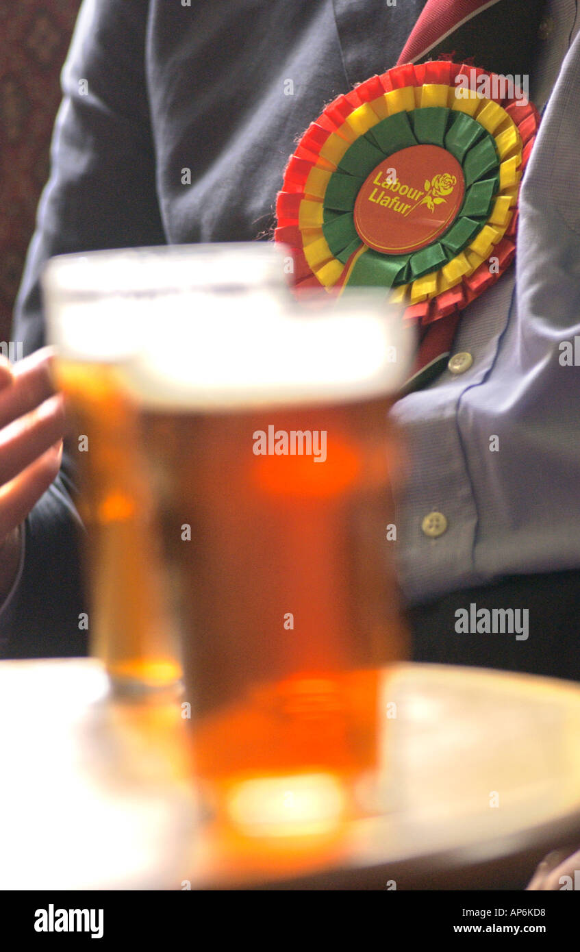 Partisan du travail portant sur la bière avec rosette la table à un club du mans dans le sud du Pays de Galles UK Banque D'Images