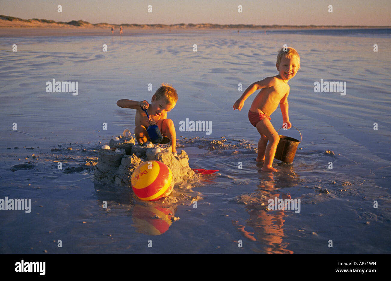 Deux jeunes frères profiter de Cable Beach à Broome Australie de l'Ouest au coucher du soleil Banque D'Images