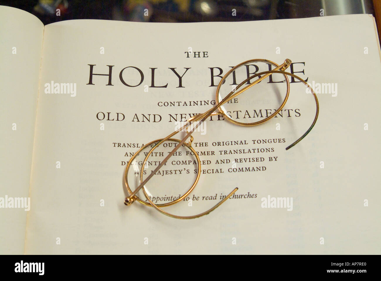 Paire de lunettes cerclées d'or sur la page de titre d'une vieille Bible Banque D'Images