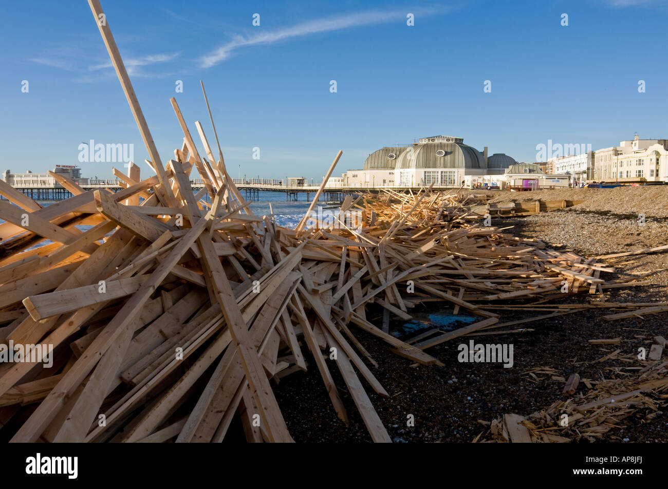 Des piles de Driftwood de l'épave du "Prince de glace' avec jetée de Worthing en arrière-plan, Sussex, England, UK. Banque D'Images