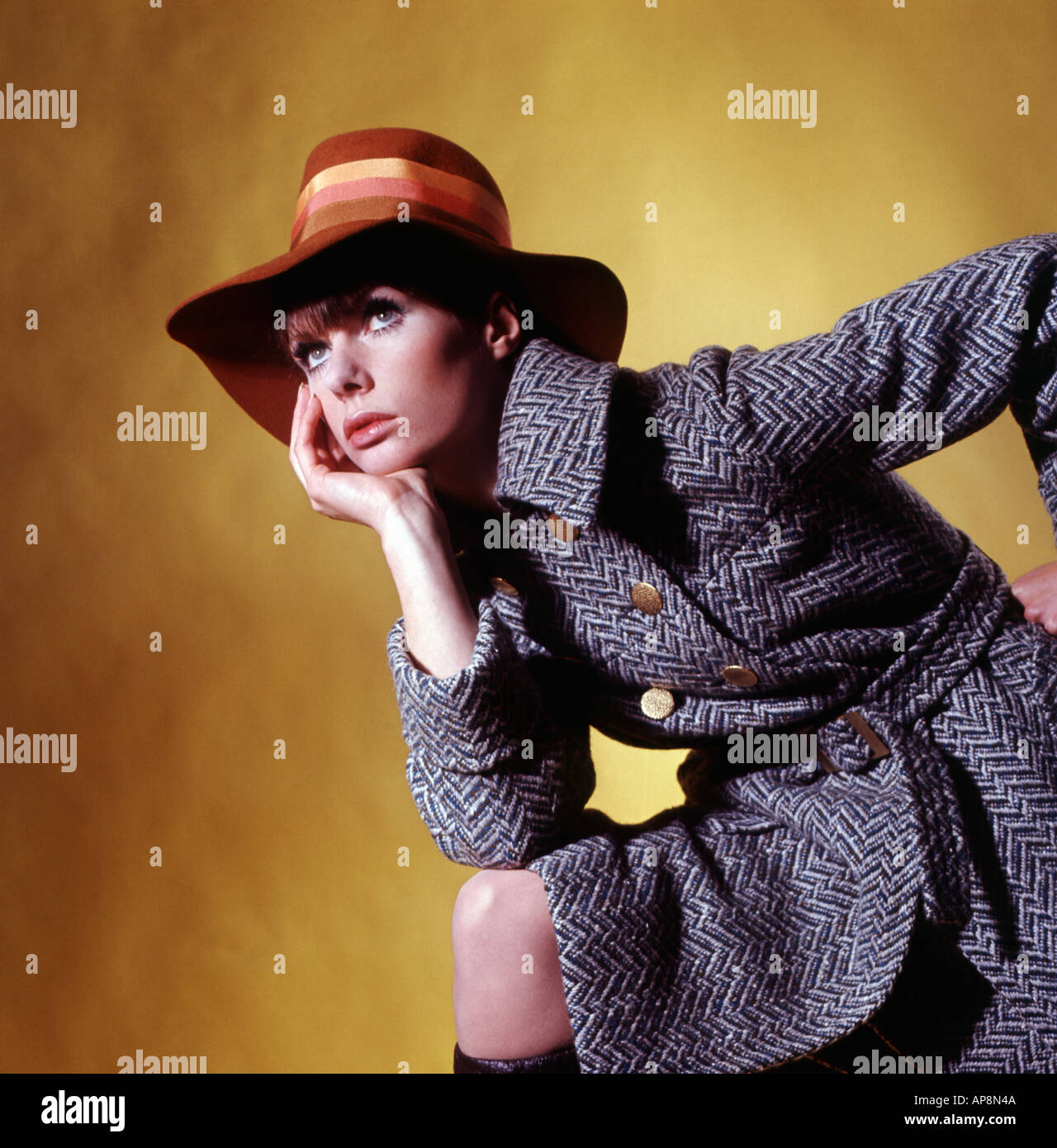 Modèle féminin posé dans un manteau en tweed années 1970 et chapeau de disquettes Banque D'Images