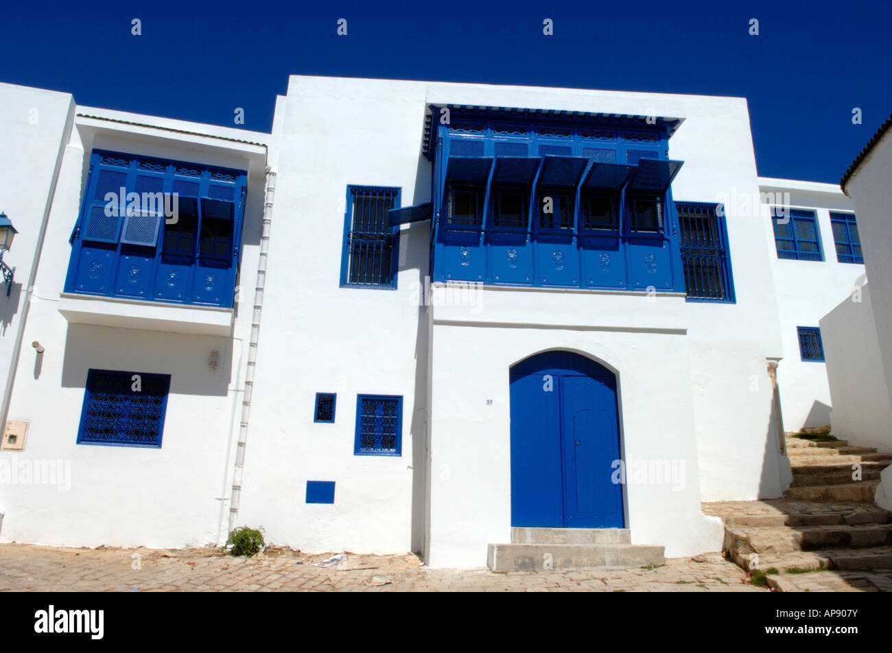 Le ciel bleu profond correspondant à la fenêtre des barbecues très contrastant avec les maisons blanchies à la chaux de Sidi Bou Said Banque D'Images