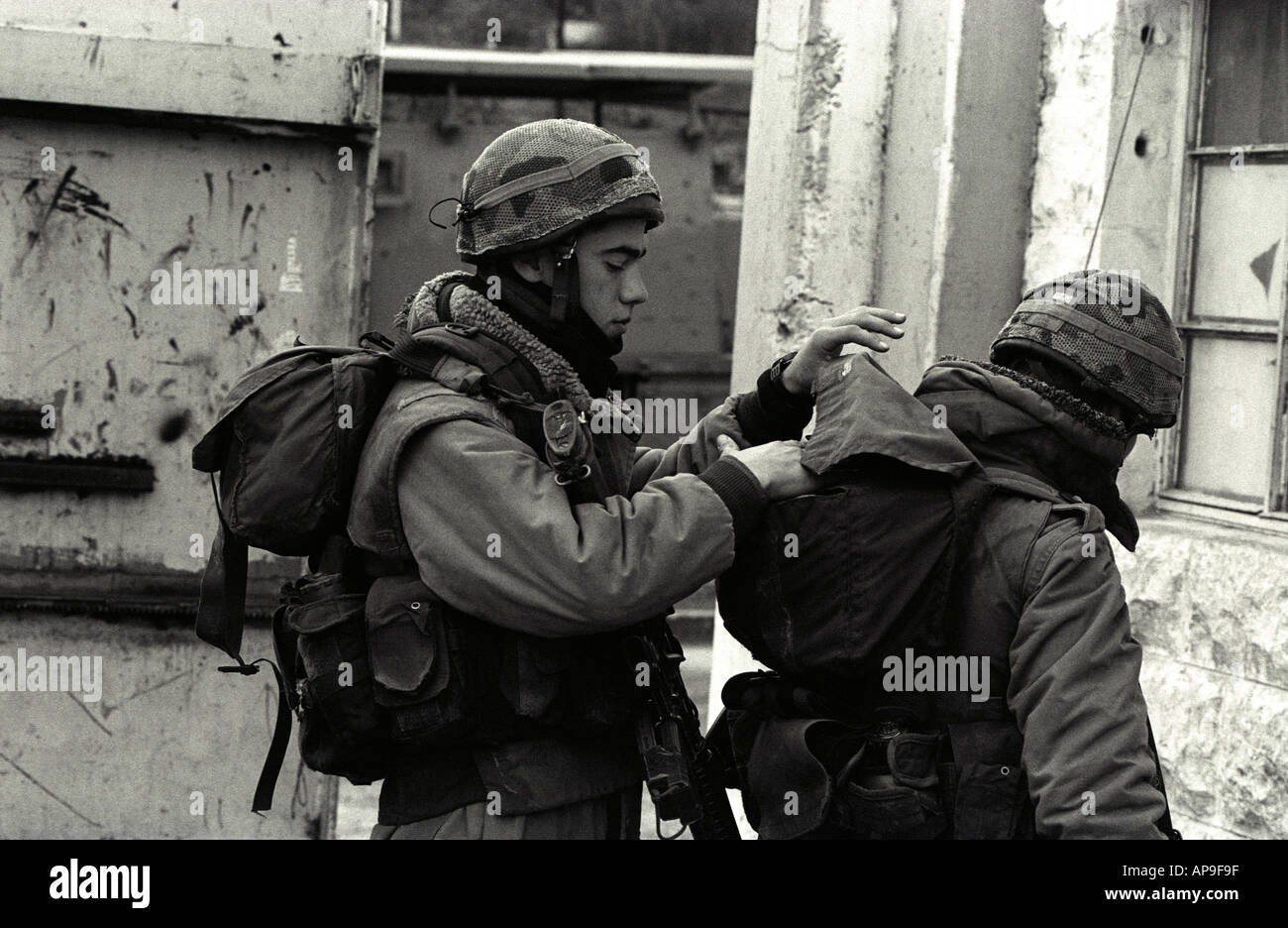 Forces de défense israéliennes (FDI) contrôle chaque kit d'autres soldats en préparation pour aller en patrouille, à Hébron, en Cisjordanie, Israël. Banque D'Images
