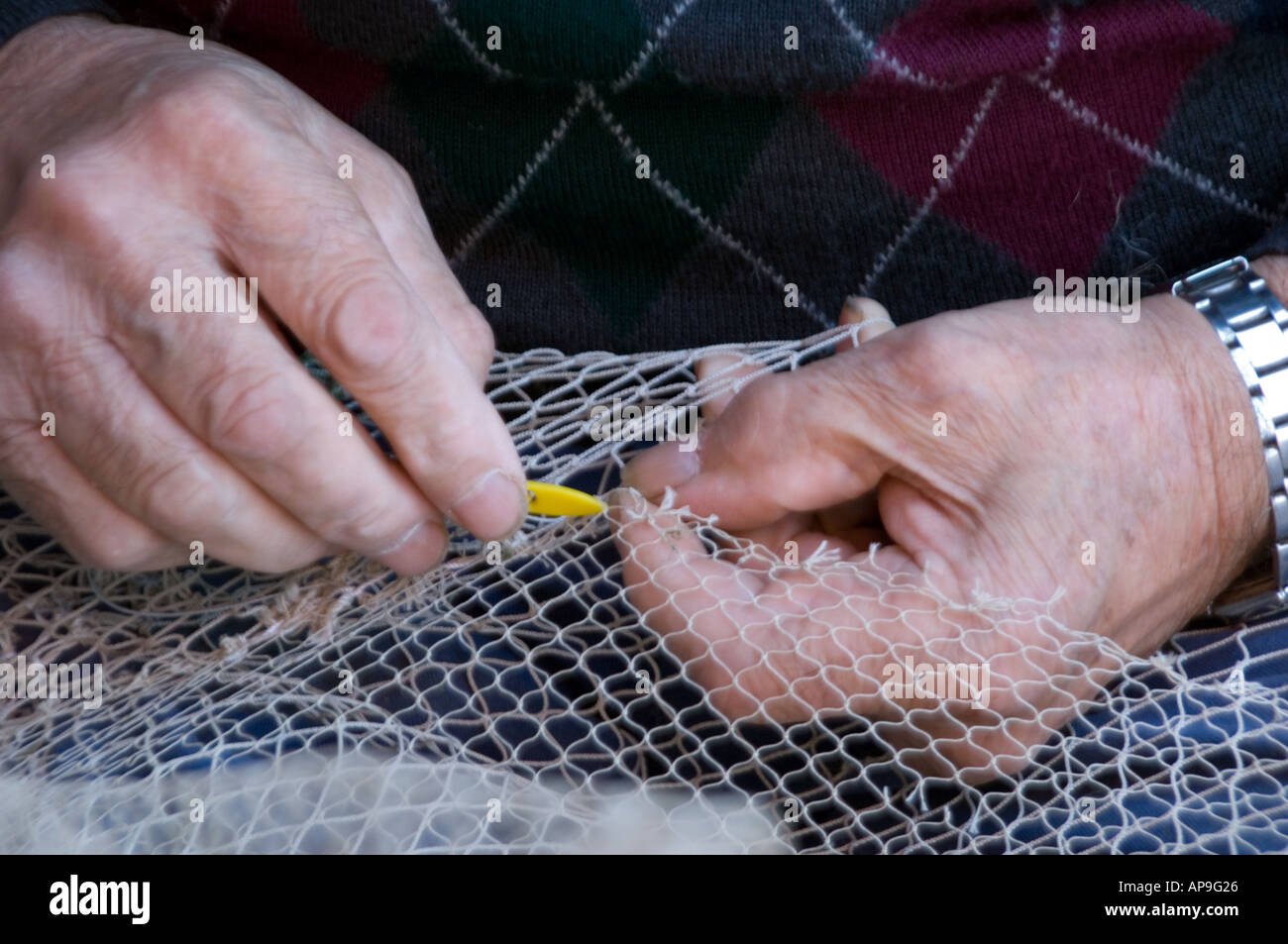 Personnes âgées mains réparer un filet de pêche à l'action Photo Stock -  Alamy