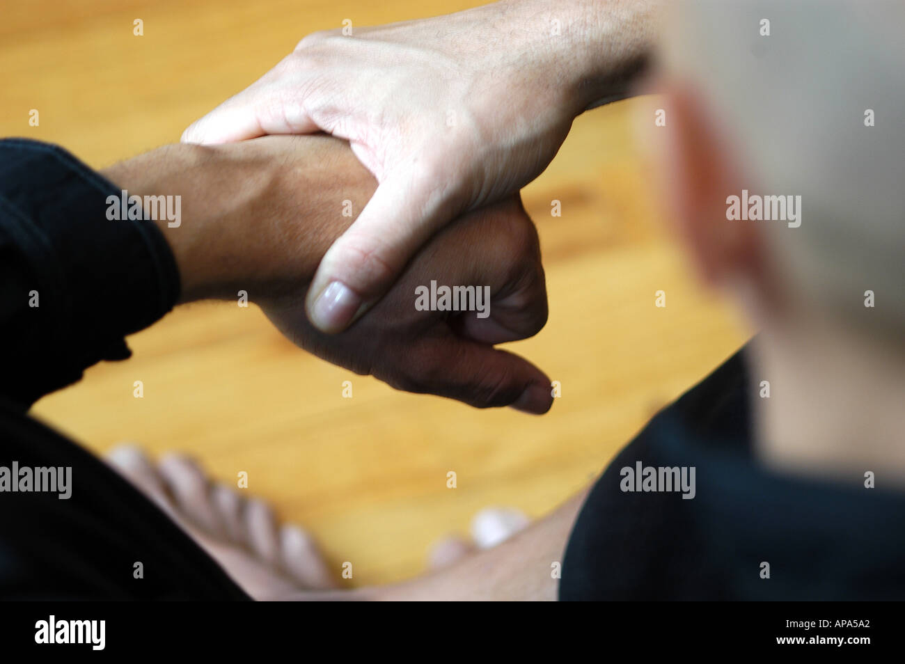 Les mains jointes sur la tête de l'épaule gauche à droite pieds partielle ci-dessous plancher bois l'horizontale Banque D'Images