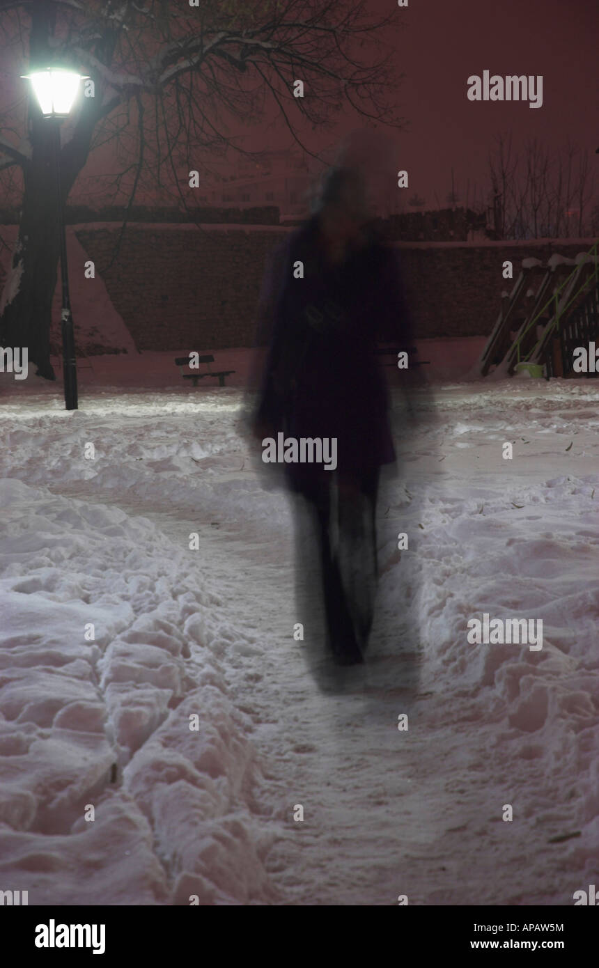 Silhouette de femme en parc de nuit blurred motion Banque D'Images